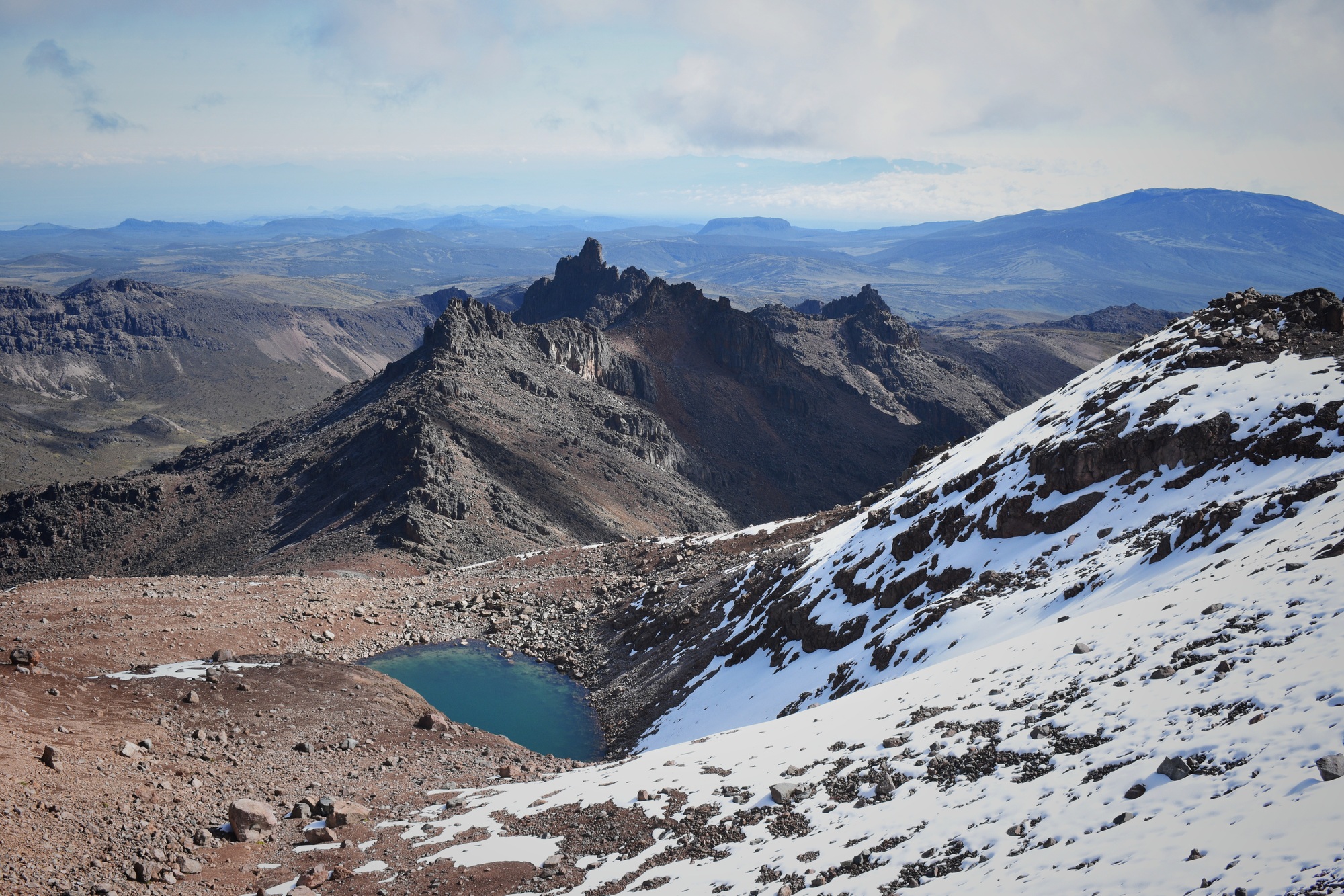Scenic view of Lake Michaelson resting under the point of the mount Kenya partially covered by snow